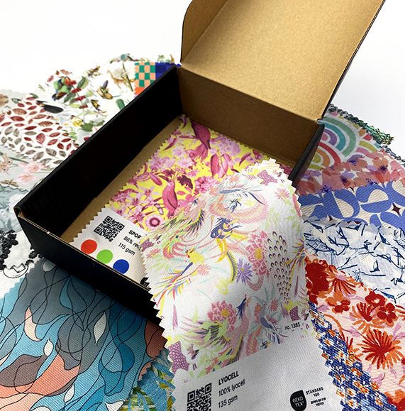 Open TISKA swatch book showing printed fabric swatches with fibre and weight labels