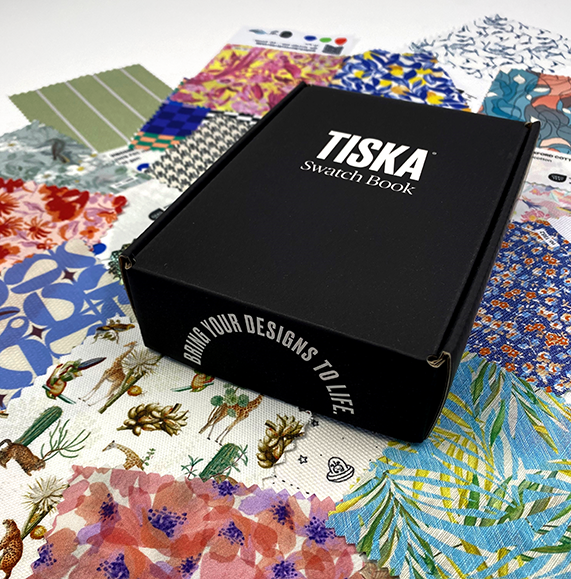 TISKA swatch book box resting on a spread of printed fabric samples