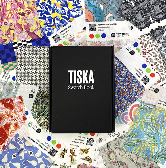 TISKA swatch book surrounded by colourful printed fabric samples